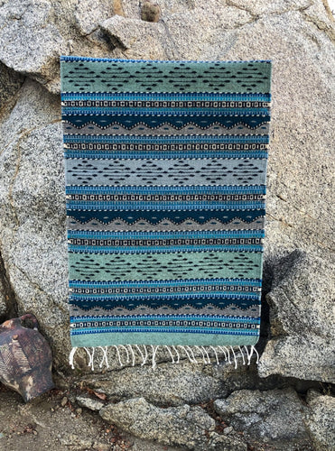 Handwoven Cortez natural wool rug, handmade in Mexico with blue, green, grey and turquoise details. 